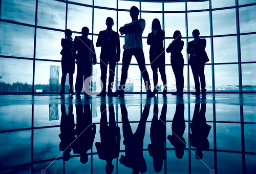 Business Team Standing Against Window With Leader In Front