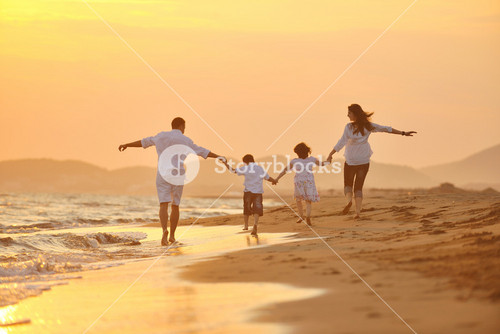 Joyful Family Enjoying Beach At Sunset